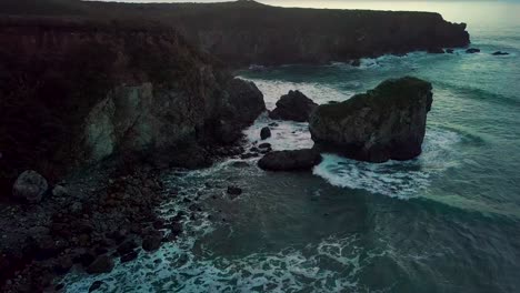 Rollende-Wellen-Des-Pazifischen-Ozeans-Krachen-In-Der-Abenddämmerung-In-Big-Sur,-Kalifornien,-Gegen-Den-Felsigen-Sand-Dollar-Strand
