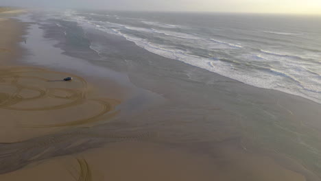 A-car-going-in-circles-on-a-sandy-beach-in-Oregon