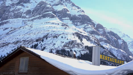 Weißer-Rauch,-Dampf,-Haus,-Restaurant,-Dach,-Schornstein,-Hintergrund,-Verschneite-Berge,-4K-Echtzeitvideo