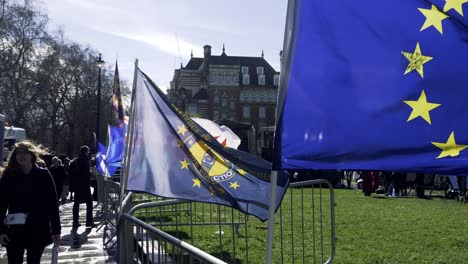 EU-and-Welsh-Flag-waving-in-wind-outside-Parliament-for-Brexit-vote,-London,-UK
