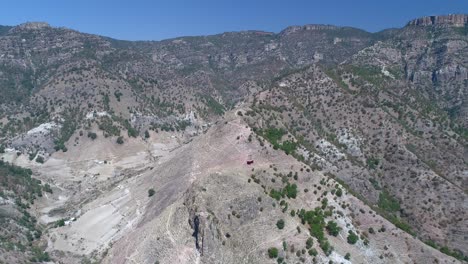 Aerial-pull-back-shot-of-a-cable-car-in-the-Urique-Canyon-in-Divisadero,-Copper-Canyon-Region,-Chihuahua