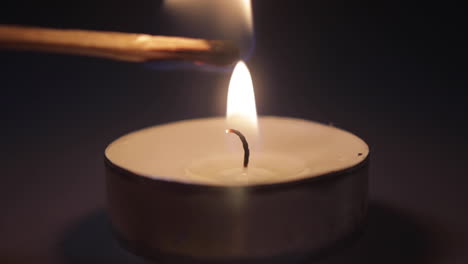 A-close-up-shot-of-a-match-being-put-into-the-flame-of-a-candle-and-exploding-igniting