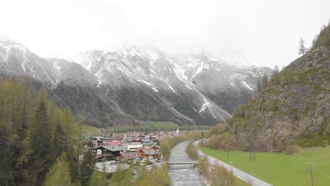aerial-footage-of-a-small-town-with-a-river-in-the-austrian-alps---Sölden,-Austria---drone