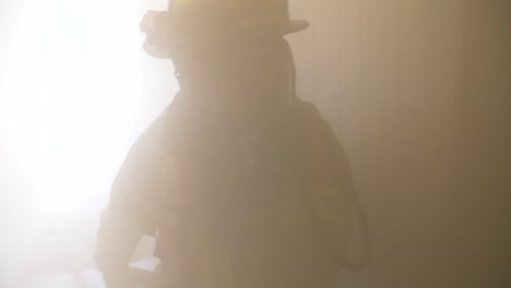 Feuerwehrmann-Zieht-In-Einem-Verrauchten-Gebäude-Einen-Feuerlöschschlauch,-Während-Er-Ein-Feuer-Bekämpft
