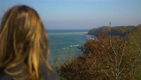 Girl-looking-at-the-sea-at-the-coast-in-autumn-in-slow-motion