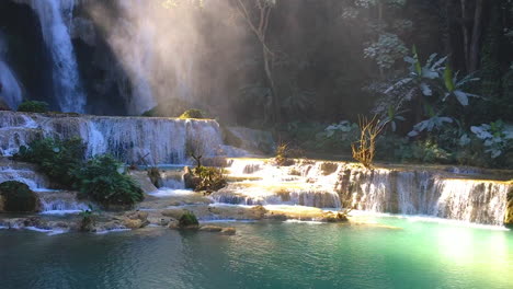 Waterfall-Kuang-Si-Falls-with-morning-mist-and-sunbeams-shine-thru-at-Luang-Prabang,-Laos