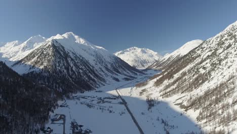 Aerial-shot-of-a-mountain-valley-in-sun-and-snow