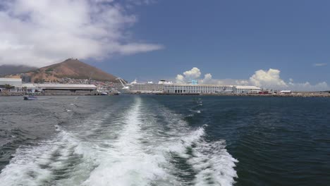 A-shot-from-the-back-of-a-Catamaran-leaving-the-V-A-Waterfront-in-Cape-Town,-South-Africa