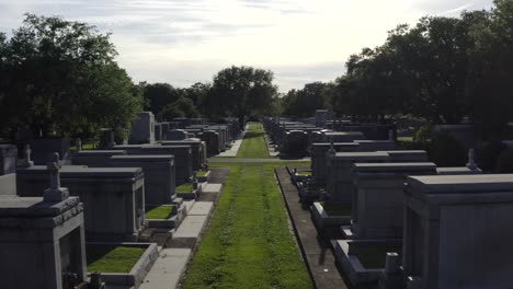 Bei-Sonnenuntergang-Durch-Mausoleen,-Statuen-Und-Große-Grabsteine-Auf-Einem-Friedhof-In-New-Orleans-Fliegen