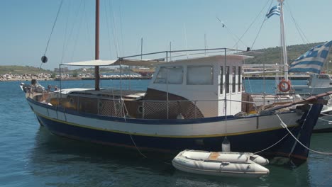 Hübsches,-Aus-Holz-Geschnitztes-Segelboot,-Das-Am-Recht-Griechischen-Dorfhafen-Aus-Nächster-Nähe-Festgemacht-Ist