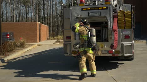 Feuerwehrmann-Zieht-Eine-Leiter-Von-Einem-Feuerwehrauto,-Während-Er-Auf-Einen-Feuerruf-Reagiert