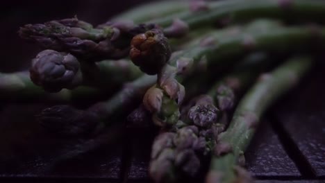Footage-of-a-bunch-of-fresh,-green-asparagus-lying-on-a-wood-table
