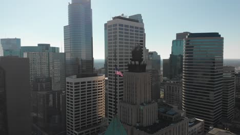 Aerial-footage-of-America's-flag,-downtown-Minneapolis-behind