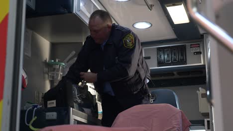 Emergency-medical-technician-prepares-medic-gear-inside-an-ambulance-to-be-ready-for-emergency-response
