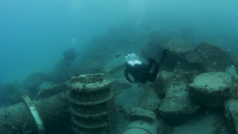 A-scuba-diver-explores-a-underwater-pipeline-network-on-the-ocean-floor