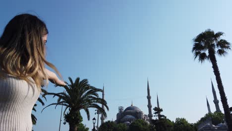 Slow-motion:Beautiful-young-girl-waves-Turkish-flag-with-view-of-Sultan-Ahmed-or-Blue-mosque-in-İstanbul,Turkey,Travel-concept