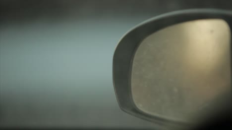 A-close-up-of-a-car-mirror-at-sunset