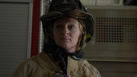 Die-Feuerwehrfrau-Zieht-Einen-Schützenden-Feuerwehrhelm-Und-Eine-Ausrüstung-An,-Während-Sie-Sich-Darauf-Vorbereitet,-Auf-Einen-Notfall-Zu-Reagieren