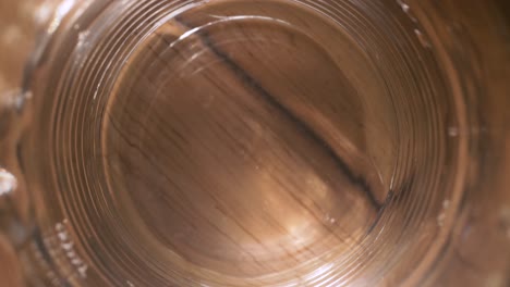 Closeup-of-Water-in-Glass-shaking-on-Wooden-Table