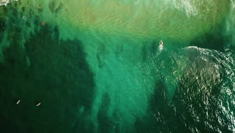 Filmische-Drohnenaufnahme-Aus-Der-Vogelperspektive,-Die-Einem-Surfer-Folgt,-Der-An-Der-Nordküste-Von-Oahu-Eine-Welle-Fängt