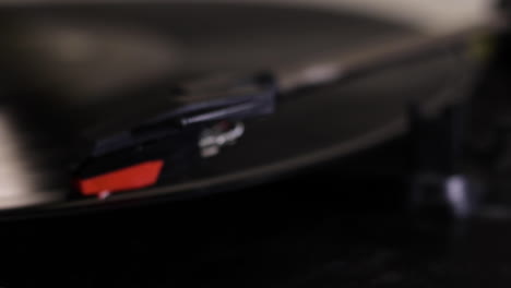 A-close-up-shot-of-a-record-player-needle-being-moved-out-of-focus-onto-a-spinning-record-vinyl