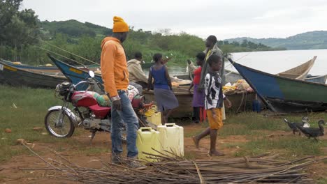 A-group-of-Africans-barter-over-fish-while-standing-around-traditional-fishing-canoes-on-the-shores-of-Lake-Victoria