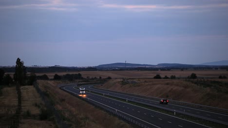 Campervan-on-a-highway-road-during-dusk-with-mountains-in-background