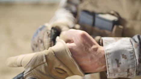 SLOW-MOTION:-A-US-Marine-positioned-in-the-desert-puts-a-tactical-glove-on-his-left-hand