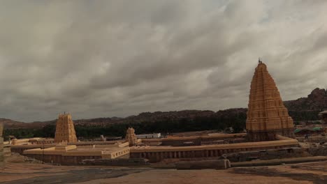 Lapso-De-Tiempo-De-Nubes-En-Movimiento-Sobre-El-Templo-Virupaksha-Gopuram-Desde-La-Cima-De-La-Colina-Hemakuta-En-Hampi,-India
