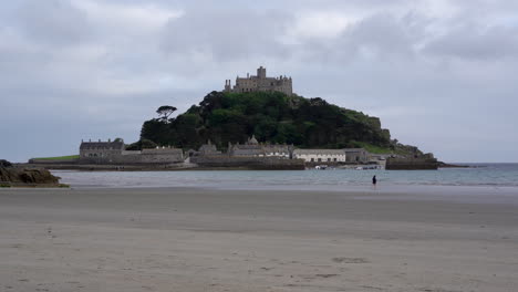 Solitary-person-running-on-the-beach-toward-the-sea-of-Marazion-in-Cornwall-right-in-front-of-Mount-St-Michael