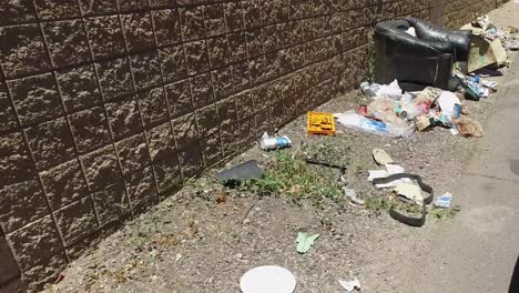 Pull-away-from-piles-of-trash-lining-a-back-alley-in-Sunnyslope,-North-Phoenix,-Arizona