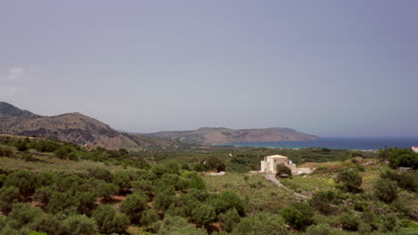 Tiefflug-über-Die-Terrasse-Einer-Luxuriösen-Griechischen-Villa-–-Miniaturpalmen,-Die-In-Der-Ferne-Die-Küste-Auf-Kreta,-Griechenland,-Freigeben