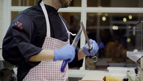 Chef-sharping-the-knives-in-the-kitchen,-Milan---Italy