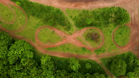 Aerial-Shot-of-Infinity-Sign-Moto-Bike-Dirt-Track-With-Grass-and-Trees-Around