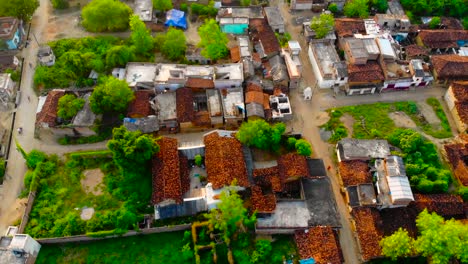 Aerial-view-through-the-palm-trees-over-road-and-roofs-of-houses-Indian-village