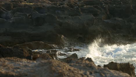 Waves-hitting-against-dark-rocks