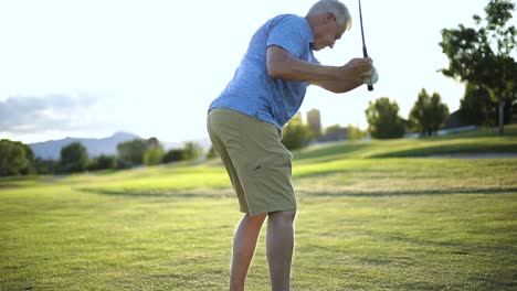 Full-body-slow-motion-shot-of-a-man-using-his-pitching-wedge-to-hit-the-golf-ball-towards-the-hole