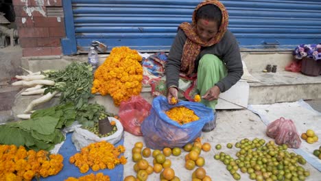 Woman-Preparing-Merrigold-Necklaces-at-the-street-market-in-Kathmandu,-Nepal