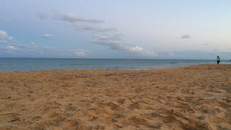 Motion-timelapse-of-a-family-walking-on-the-beach-enjoying-the-seacape-water-veiw-sand-sea-air,-kids-children-horizontal-golden-hour-sunset