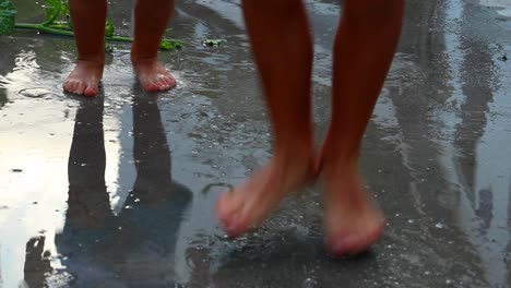 Siblings-Children-happy-wet-feet-jumping-up-and-down-in-water-puddle,-barefoot-child´s-play-outdoor-fun---games-childhood-siluete-reflections-infant-toddler-kids-H2O-boys-forever-young