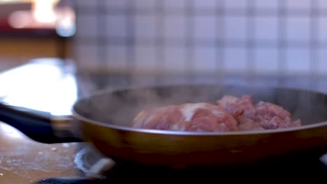 Man-is-busy-cooking-bacon-in-a-frying-pan
