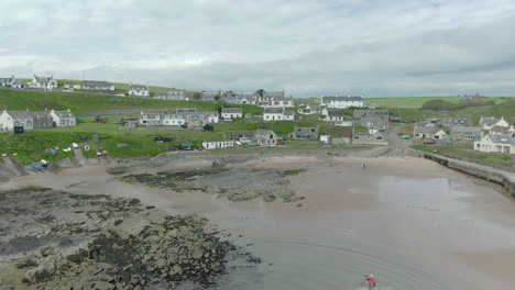 An-aerial-view-of-Collieston-village-from-the-sea-on-a-cloudy-day