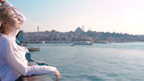 Slow-Motion:Beautiful-girl-stands-over-Galata-Bridge-and-enjoys-view-of-bosphorus-in-Istanbul,Turkey