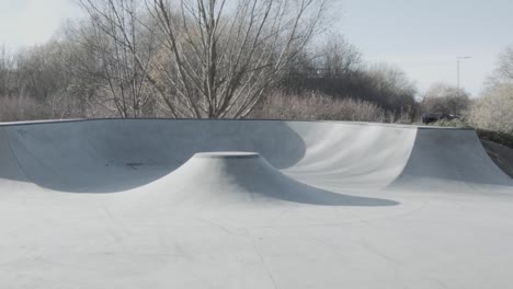Skating-through-an-empty-concrete-skatepark-on-a-sunny-day