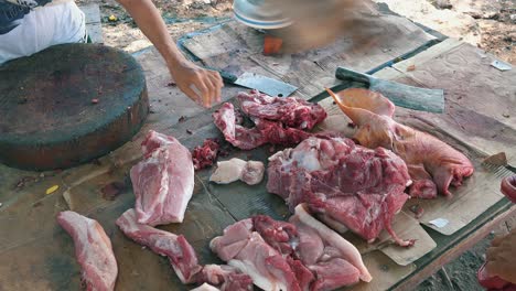 Medium-Shot-of-a-Girl-Butchering-a-Pig-on-a-Small-Market-Stall-by-the-Side-of-the-Street