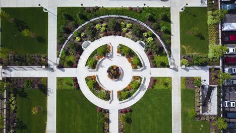 Bird's-Eye-Drone-shot-lowering-down-on-a-beautifully-designed-walking-path-which-is-surrounded-by-lush-and-colorful-flowers