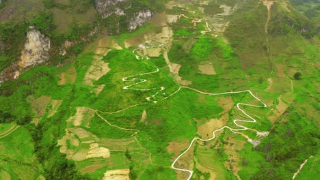 Die-Nach-Oben-Geneigte-Luftaufnahme-Zeigt-Eine-Kurvenreiche-Straße,-Die-In-Die-Berge-Des-Wunderschönen-Ma-Pi-Leng-Passes-Im-Norden-Vietnams-Eingeschnitten-Ist
