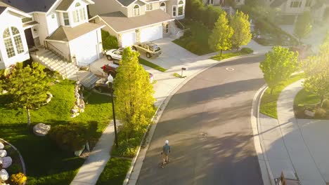 Cinematic-Drone-Shot-of-a-boy-riding-his-skateboard-down-a-hill-going-really-fast-and-then-coming-to-a-stop-by-putting-his-hands-on-the-ground-and-sliding