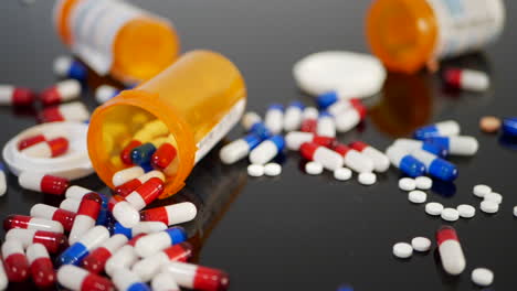 Many-prescription-pills,-drugs-and-antidepressants-spilling-in-slow-motion-from-an-orange-pharmacy-medicine-bottle-SLIDE-RIGHT