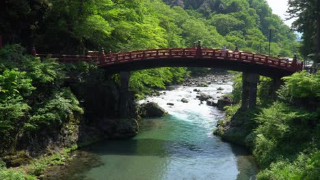Red-Shinkyo-Bridge,-crossing-a-flowing-river-in-Nikko,-Japan
